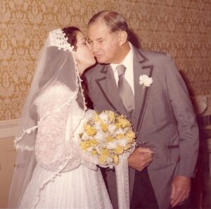 vintage photo of a daughter kissing her father on her wedding day