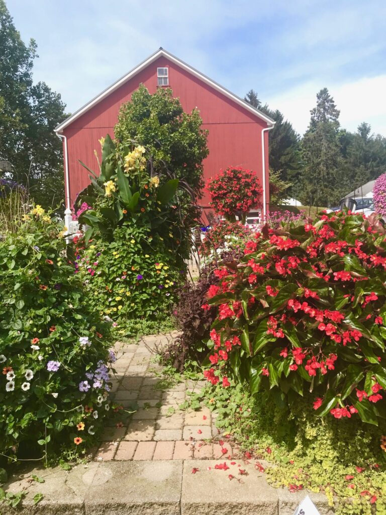 red barn with lots of flowers in front