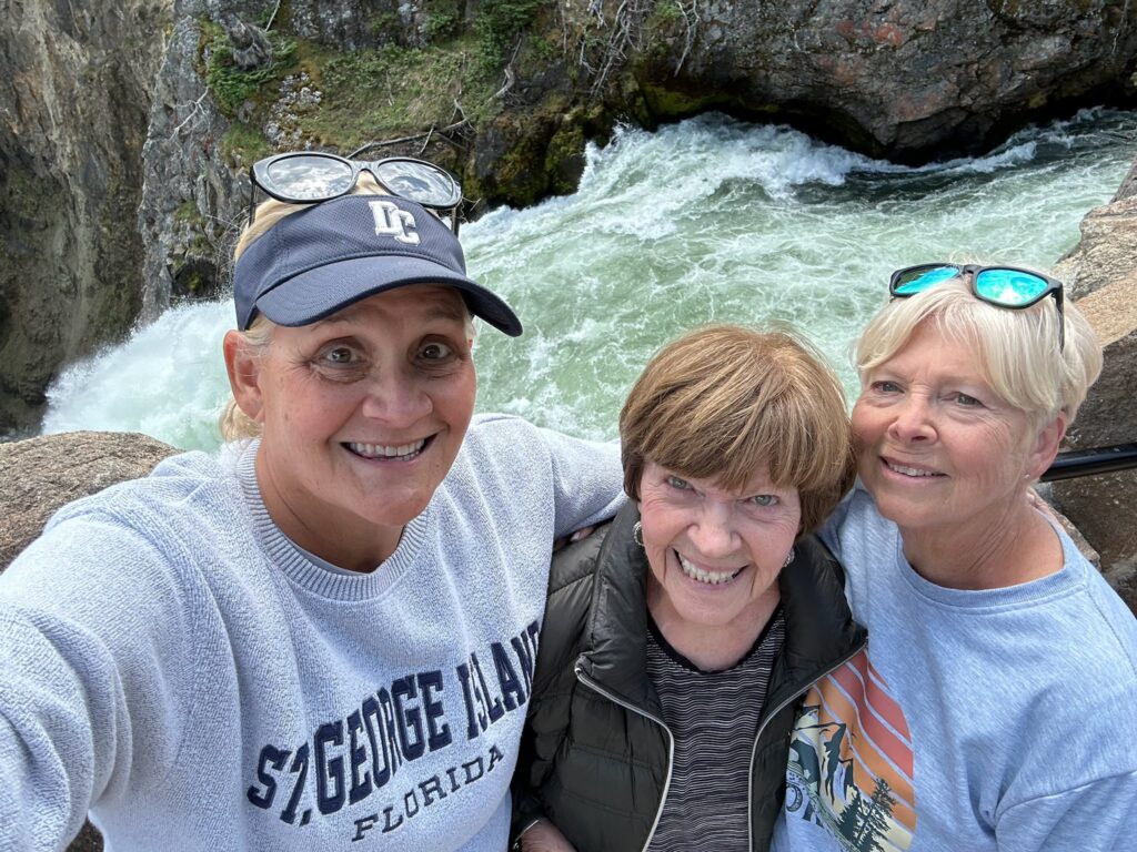 3 women in front of a roaring river