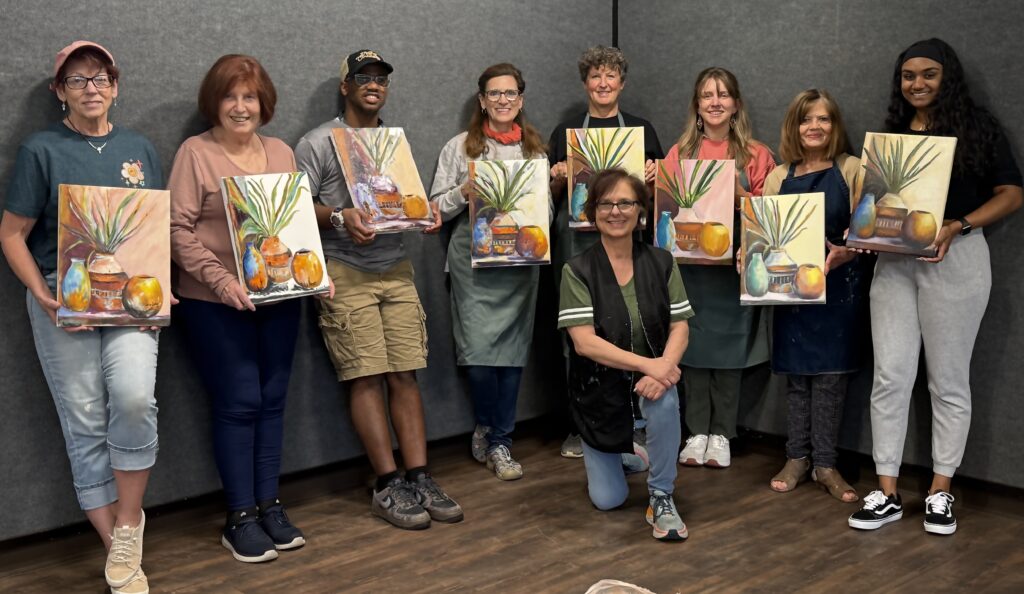 Martha with a class sharing their finished paintings