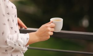 womans hand holding coffee cup